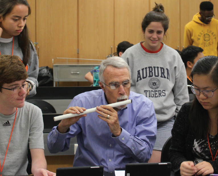 Dean Giordano playing a homemade flute at the Summer Science Institute.