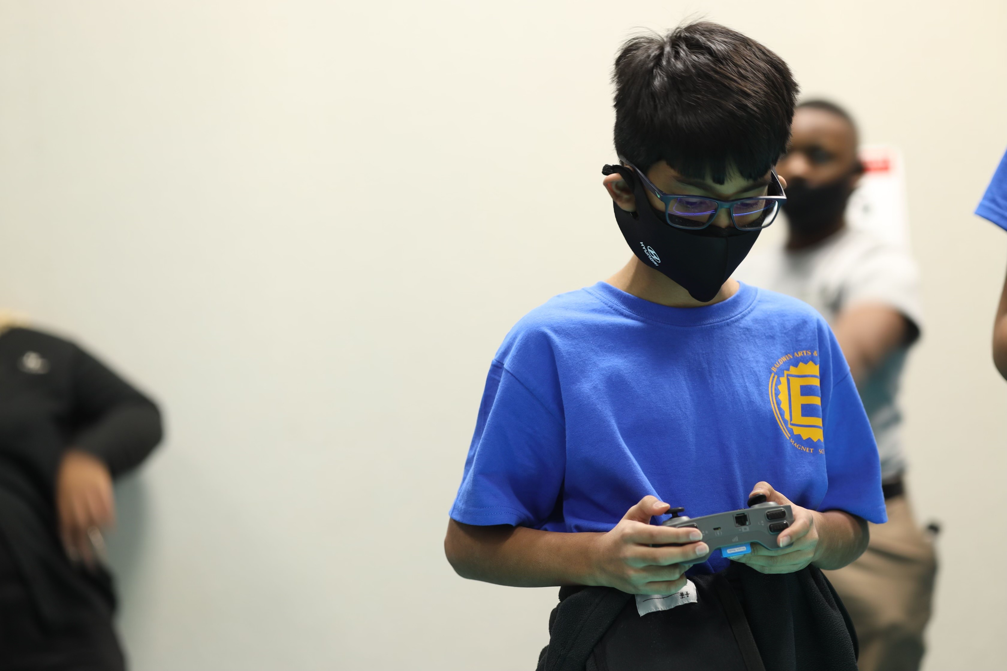 A student holding a controller for a robot competes at the HIRE Robotics Event on Jan. 28.