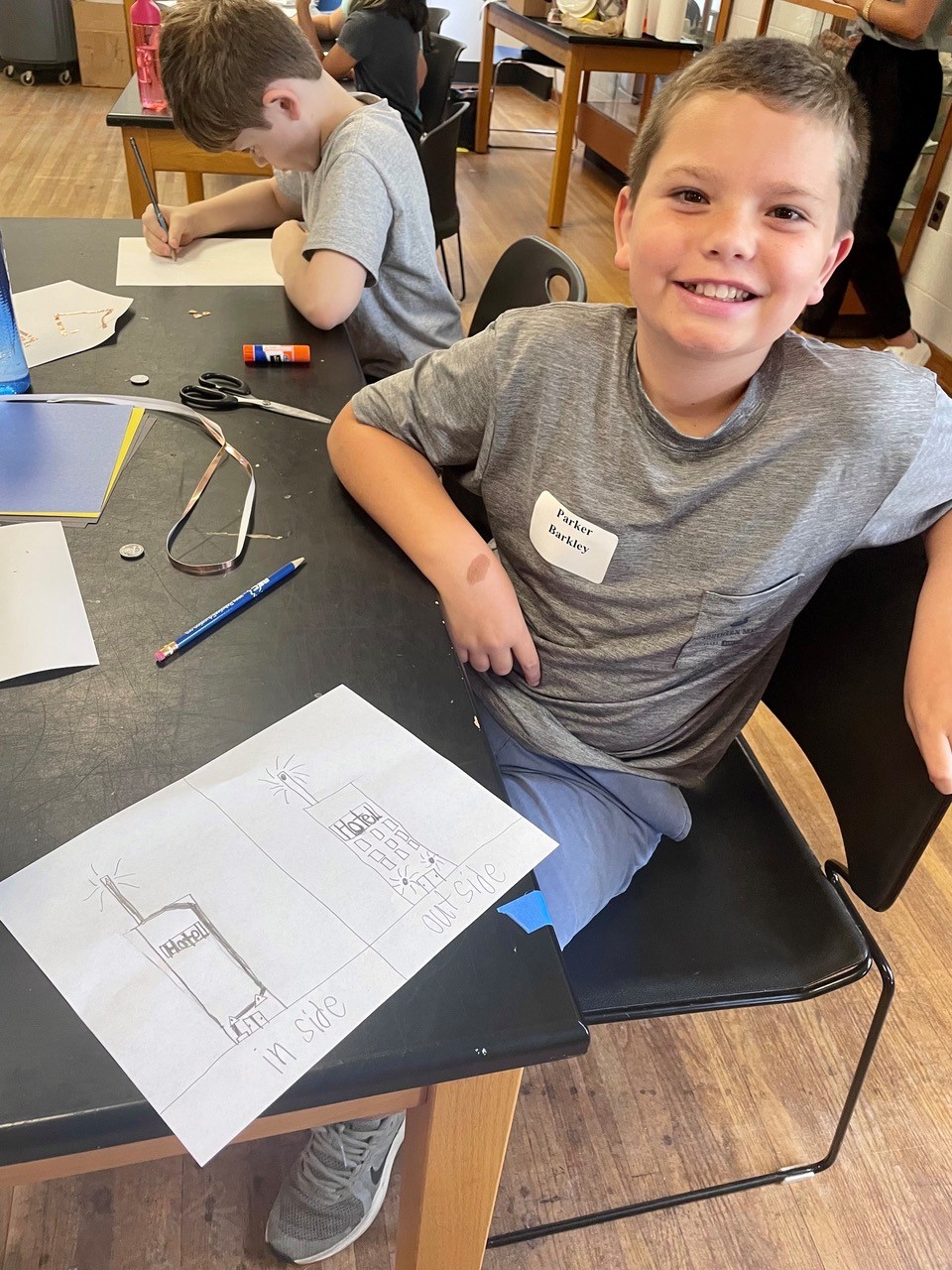 Student Parker Barkley learns about the engineering design process by sketching how lights and circuits will be placed in his paper skyscraper.