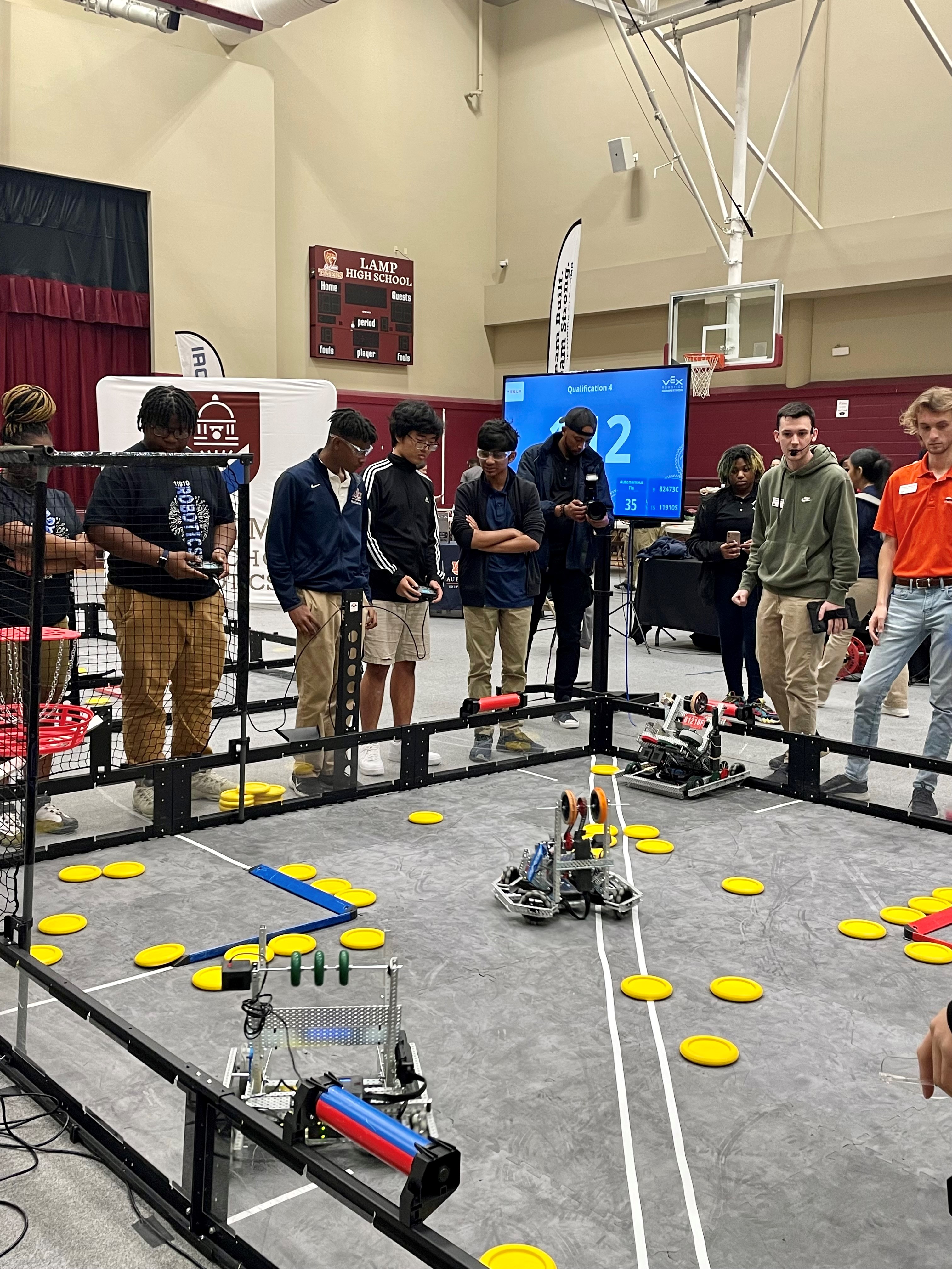 Student teams skillfully maneuver VEX robots during competition qualifying matches.
