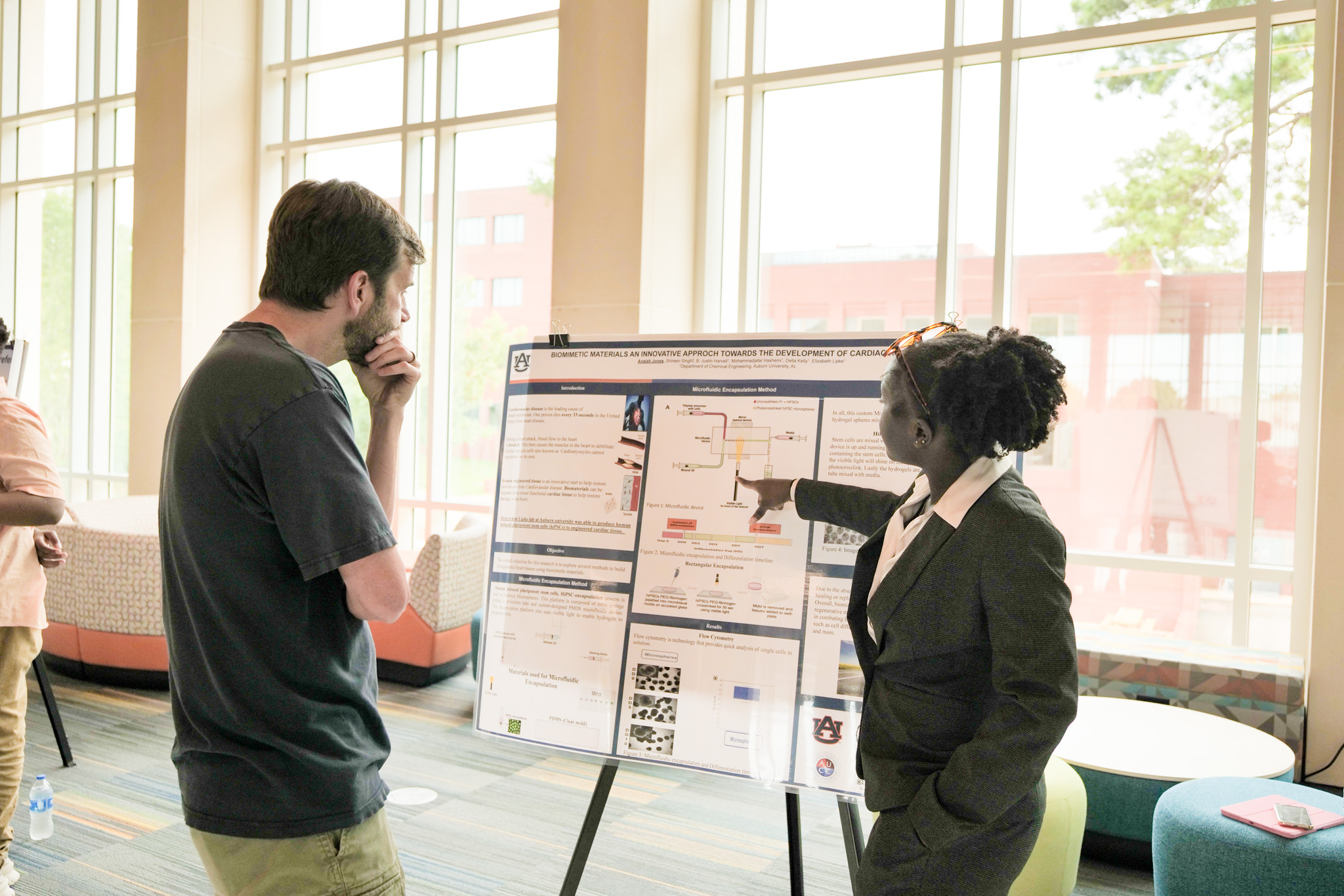 Anaiah Jones discusses her research poster and points out methods she learned this summer.
