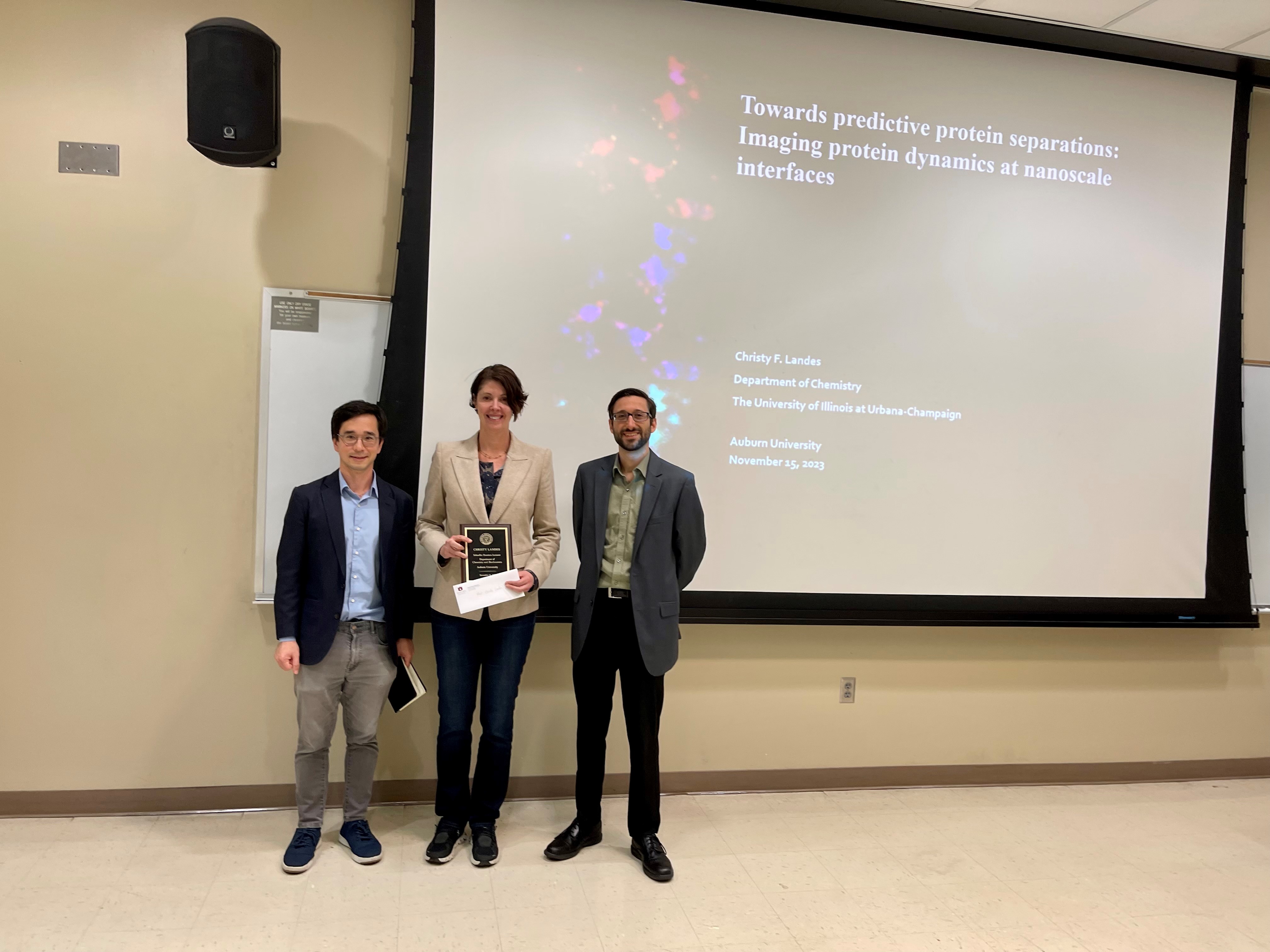 Left to right: Paul Ohno, Christy F. Landes and Chris Grieco. Ohno and Grieco presented Landes with the Schneller Frontiers Lecture plaque. 