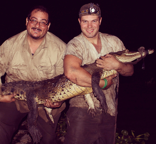 Murray and Sasa pose with a restrained crocodile after a capture.