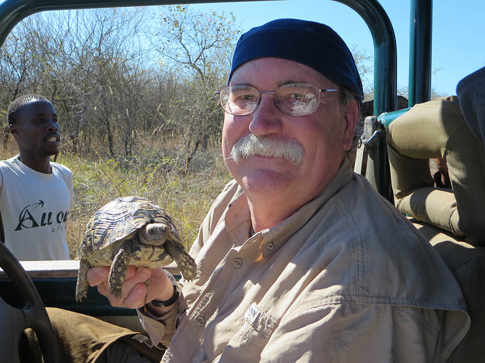 Michael Wooten holding a turtle while sitting in a car in Swaziland