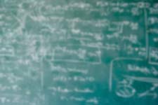 Blurry chalkboard with illegible writing.