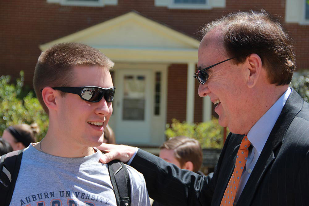 President Jay Gogue pats a student on the shoulder during an event on the Haley Concourse.