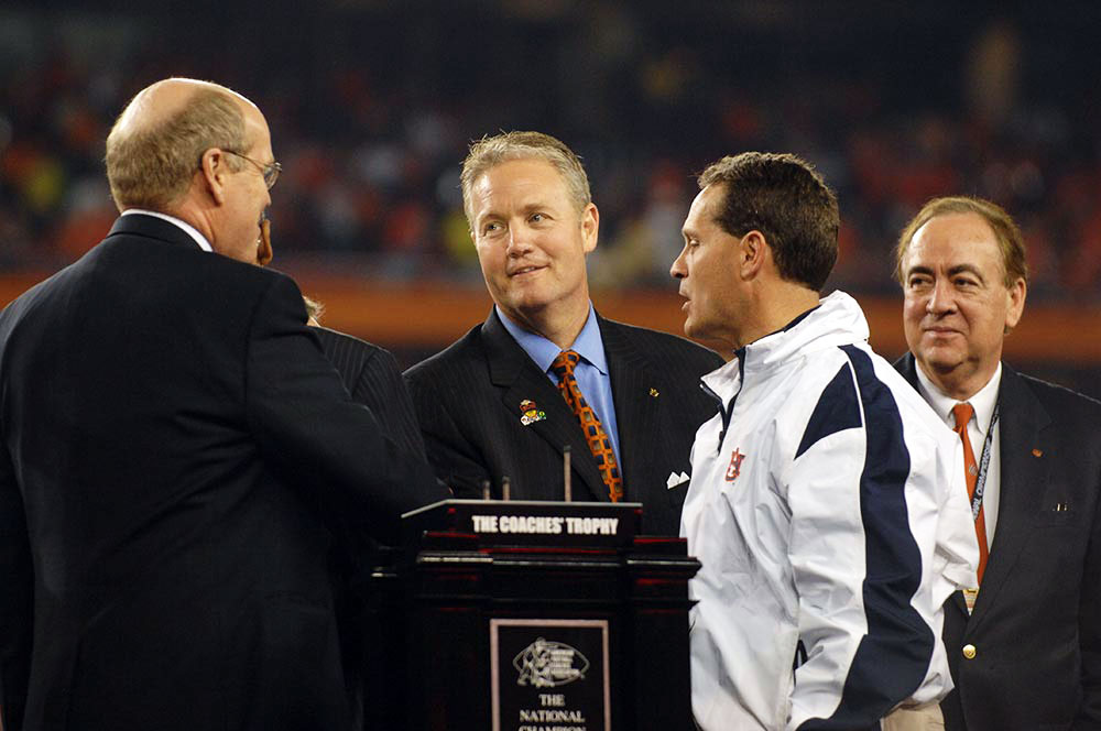 Jay Gogue and others are on stage to receive The Coaches’ Trophy after Auburn’s football team won the 2010 National Championship.