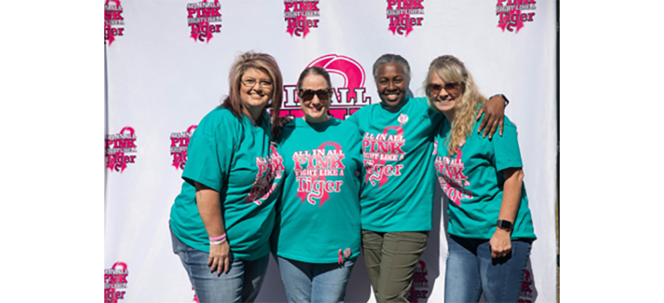 A group of women wearing matching All In All Pink shirts.