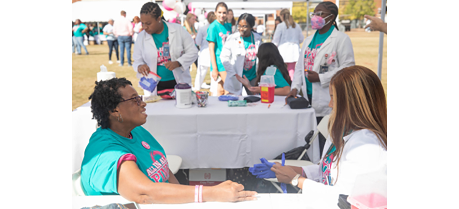 A group of women sitting at a table for a healthcare screening.