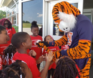 Boys and Girls Club members gather around Aubie as he shows them his tail.