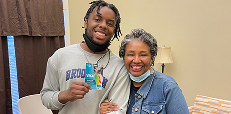 Young student and mentor pose for photo during gift card giveaway