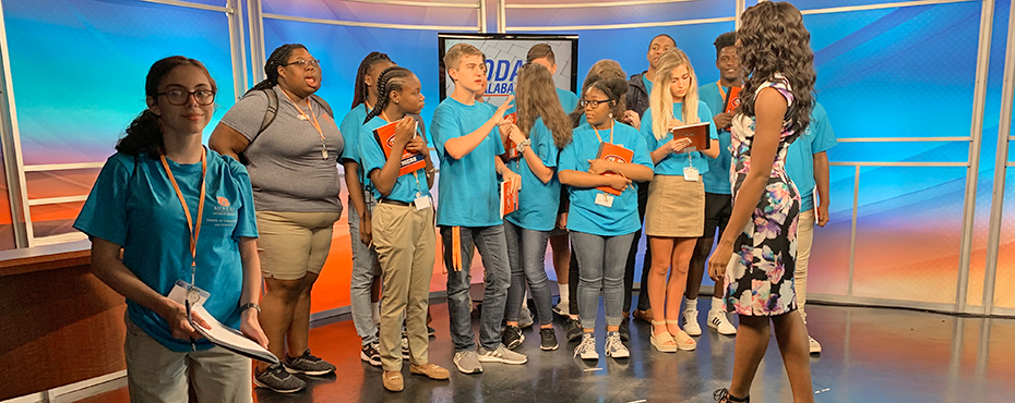 Campers stand on news stage during tour of WSFA news building.