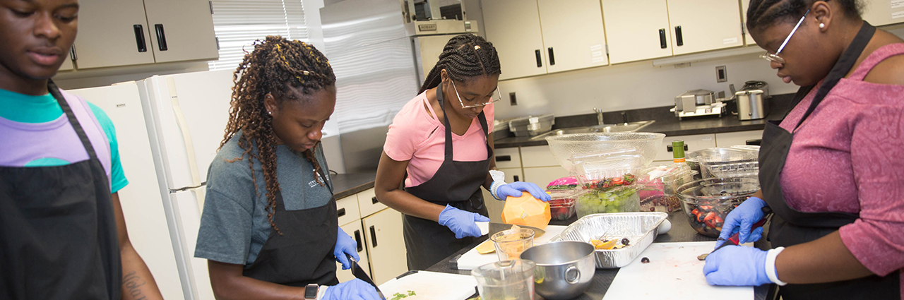 Camp participants cutting up fruits and vegetables at Chef Tech academy.