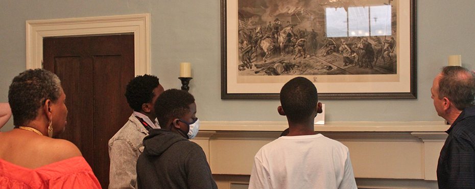 Young Scholars viewing a historic photograh on the wall.