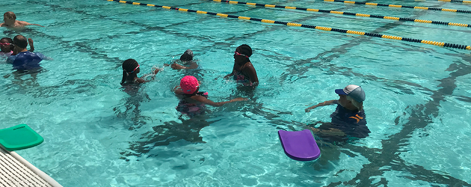Students in swimming pool learn from instructors