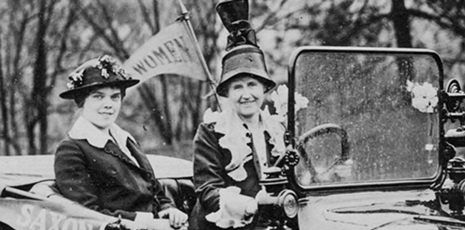 Two women campaign for women's suffrage in old timey car