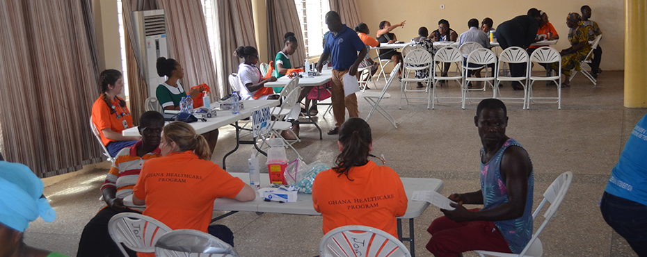 Auburn University Students sitting at tables providing minor health services to Ghana residents