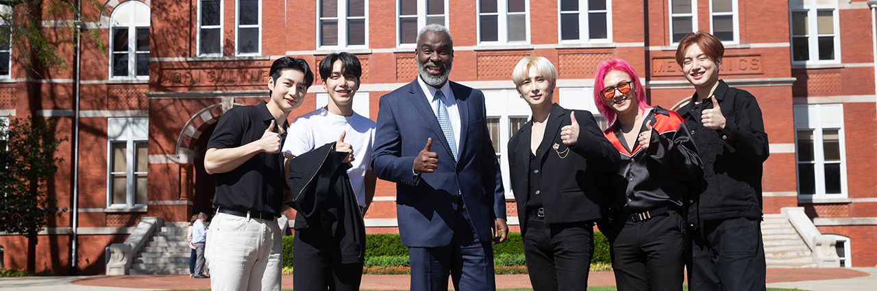 Dr. Cook with MustBe Kpop group in front of Samford