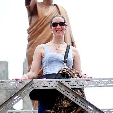 An Auburn student poses in front of gold statue in Ghana, Africa
