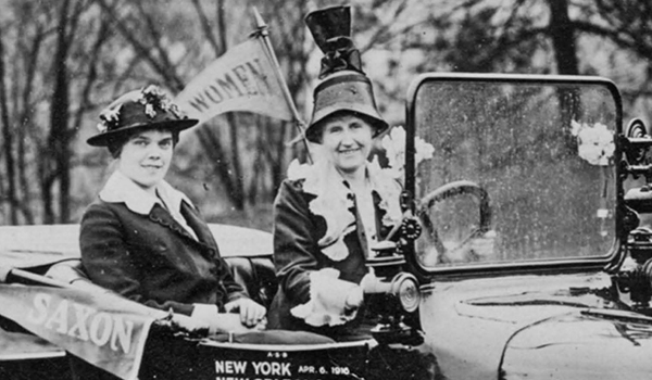 Two women in 1900s sitting in old timey car