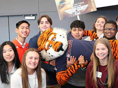 Group of Students holding Aubie the AU Mascot and a sign