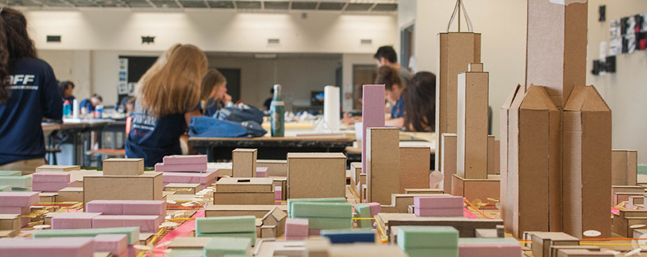 A glimpse of a cardboard model of New Orleans, LA and the students working in the background.