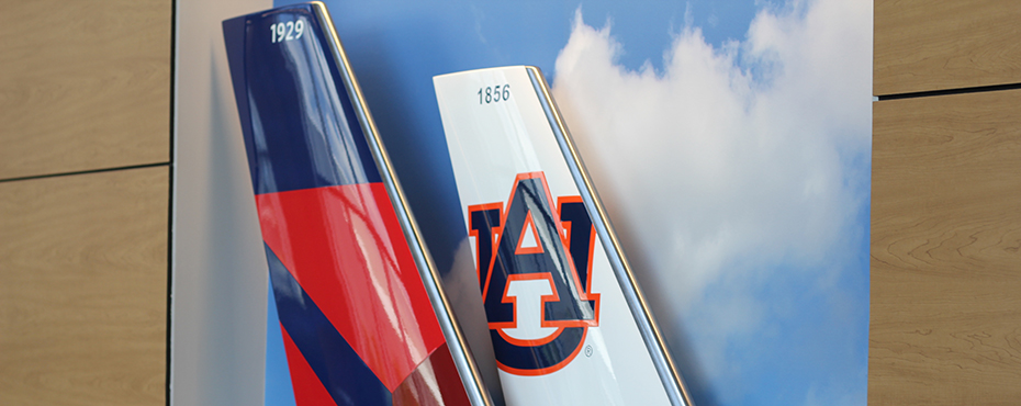 Closeup of tail of plane with AU logo on it