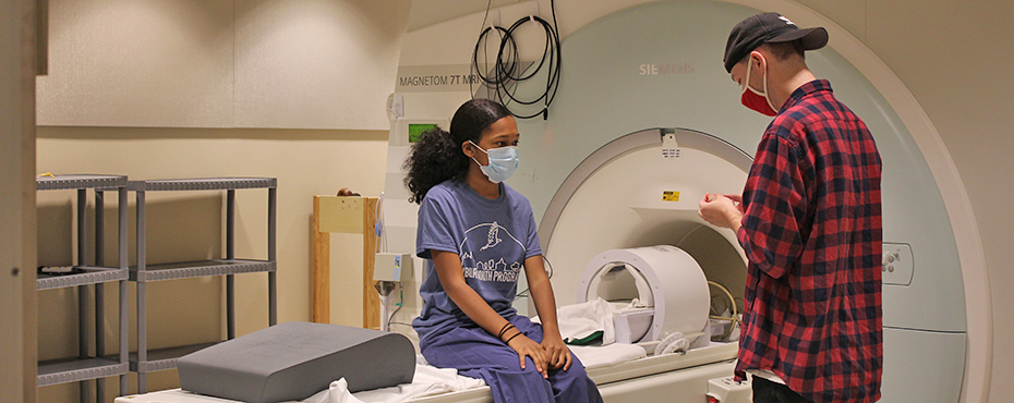 Student sitting on MRI machine