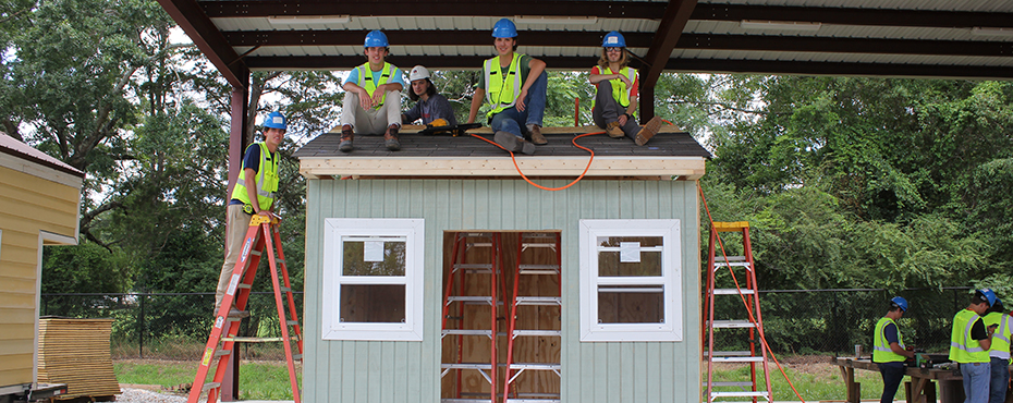 Students sitting on the roof of a shed