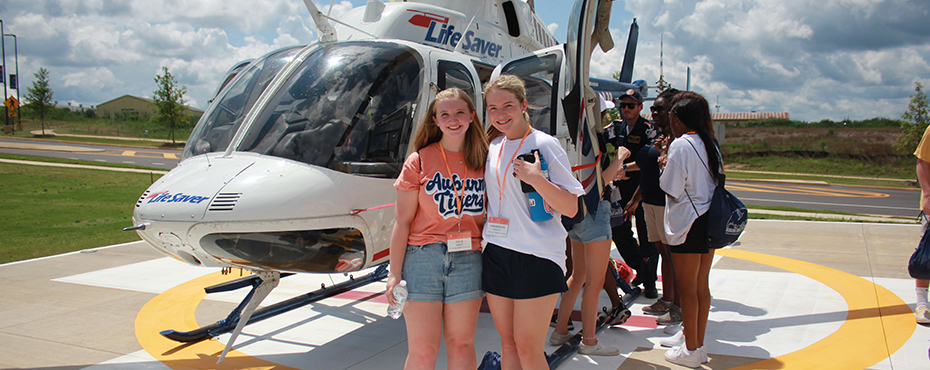 Students on helipad in front of helicopter
