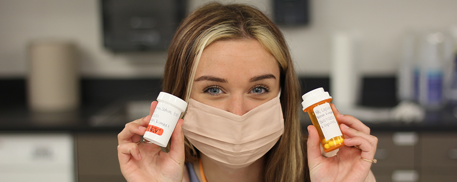 Student posing with prescriptions