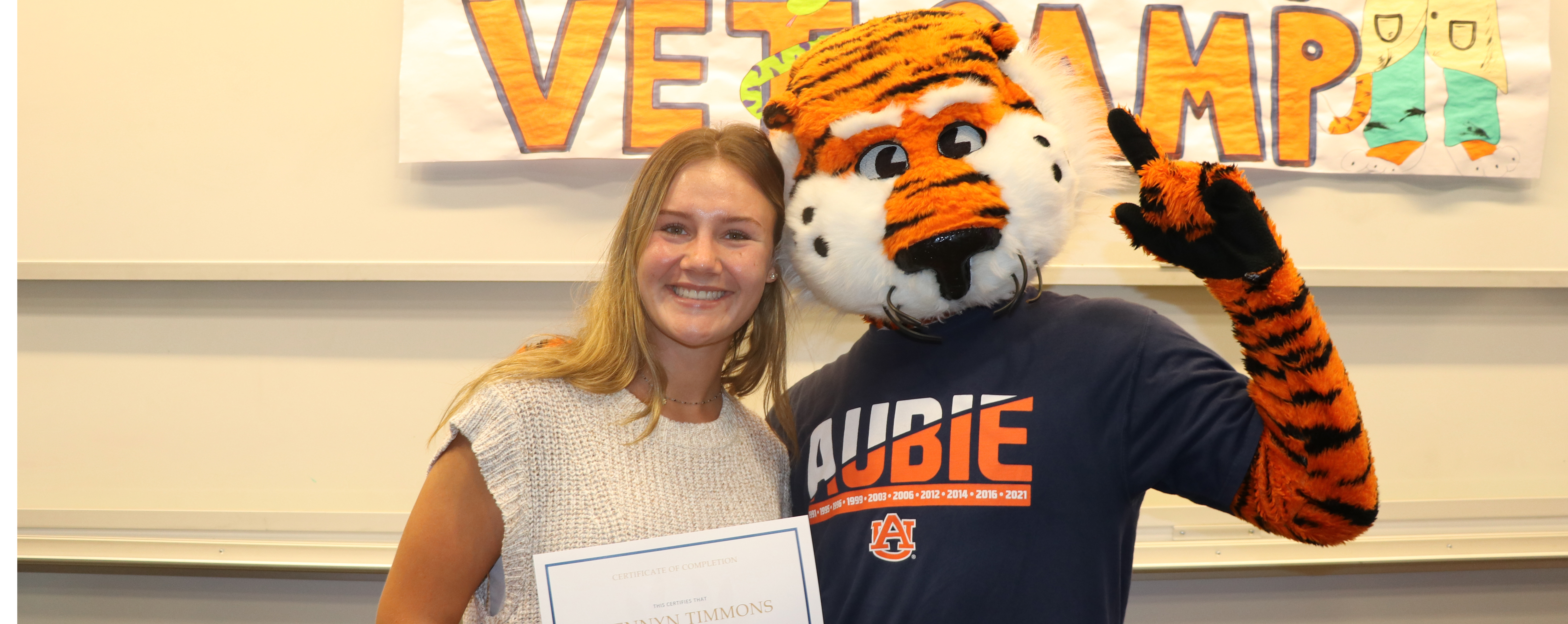 Camper Brennyn smiles for a picture with Aubie the Tiger.