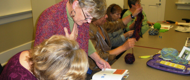 A teacher inspects a students knitting