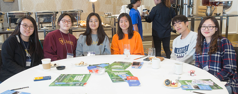 Korean students pose for photo together at table as they attend the conference.