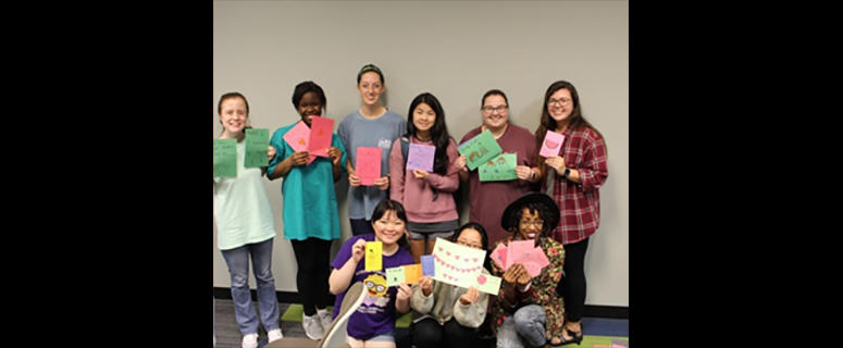 Circle K International students taking a picture with letters and cards they made for a local nursing home. 