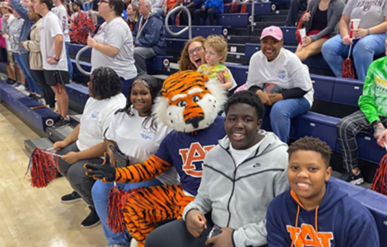 Members of YPiT taking a picture with Aubie while attending a basketball game.