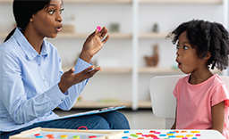 An older woman performs a vocalization exercise with a young child